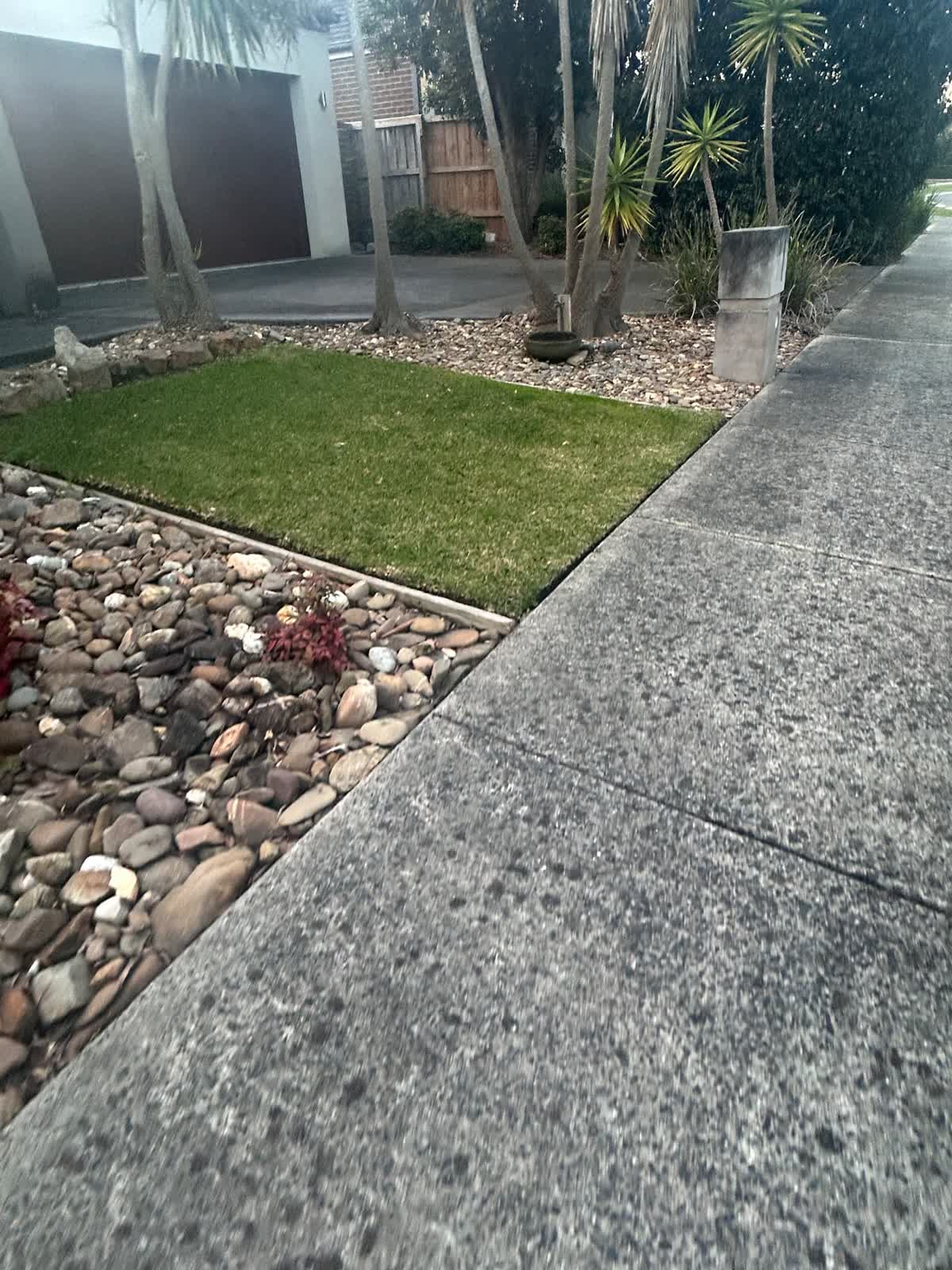Residential lawn mowing — Berwick. Compact front lawn mown and edged clean against the pebble beds and driveway.