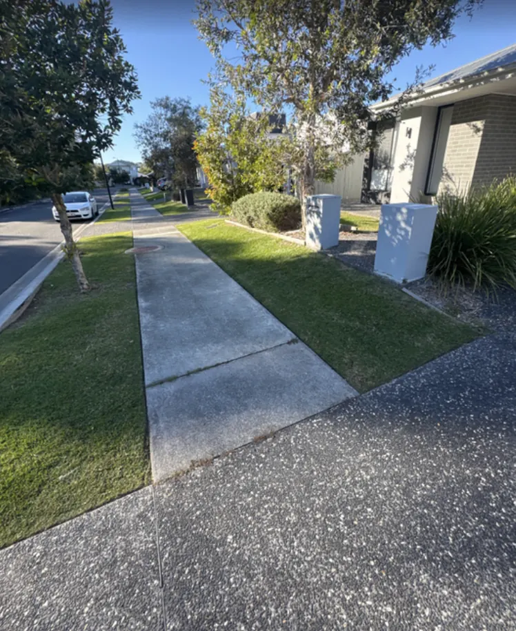 Fortnightly lawn maintenance — Berwick. Nature strip and front lawn mowed with crisp edges along the footpath and driveway, on a fortnightly run.